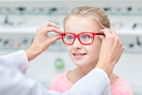 child in the optician trying on glasses