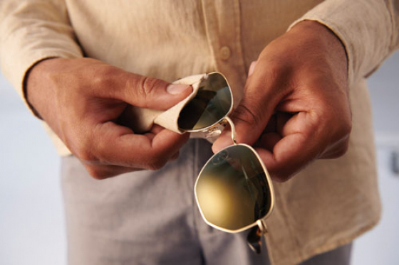 Cleaning sunglasses with a lens cloth